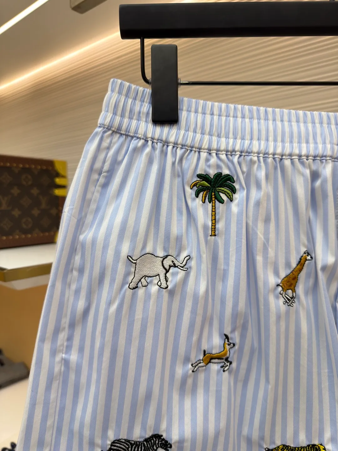LOUIS VUITTON Animal and plant nostalgic style embroidered striped shorts ●Original version: purchased and developed by 14616 ●Item number: 1682542-A75 ●Fabric: cotton fabric ●Technology: embroidery production ●Color: blue ●Version: fitted version ●Weight: about 205 grams ●Size: S-M-L-XL ●Description: Made of high-count pure cotton poplin fabric. After pre-washing process, it feels smooth and breathable. It has both drape and stiffness, and is not easy to wrinkle and deform. The blue and white vertical stripes on the body are woven with yarn-dyed technology, and the texture is clear and does not fade. The animal and coconut tree patterns are presented with sophisticated embroidery technology. The embroidery threads are full of color and the stitches are dense. The patterns are three-dimensional and vivid, forming a rich visual hierarchy with the stripe base. The shirt has a Cuban collar style, with smooth necklines, custom mother-of-pearl buttons at the placket, and a warm texture. The overall shape is loose, the shoulder joints are straight and fine, the cuffs are cuffed with exquisite craftsmanship, custom accessories and three logos are complete, and the details are full of luxury craftsmanship. It is suitable for casual vacations and daily outings, etc. The overall wiring is straight and delicate, the fabric is comfortable and soft, and the color is consistent without color difference. It can be matched with the same style to create a fashionable look and control various occasions. Customized accessories, complete with three standards, same style for men and women!